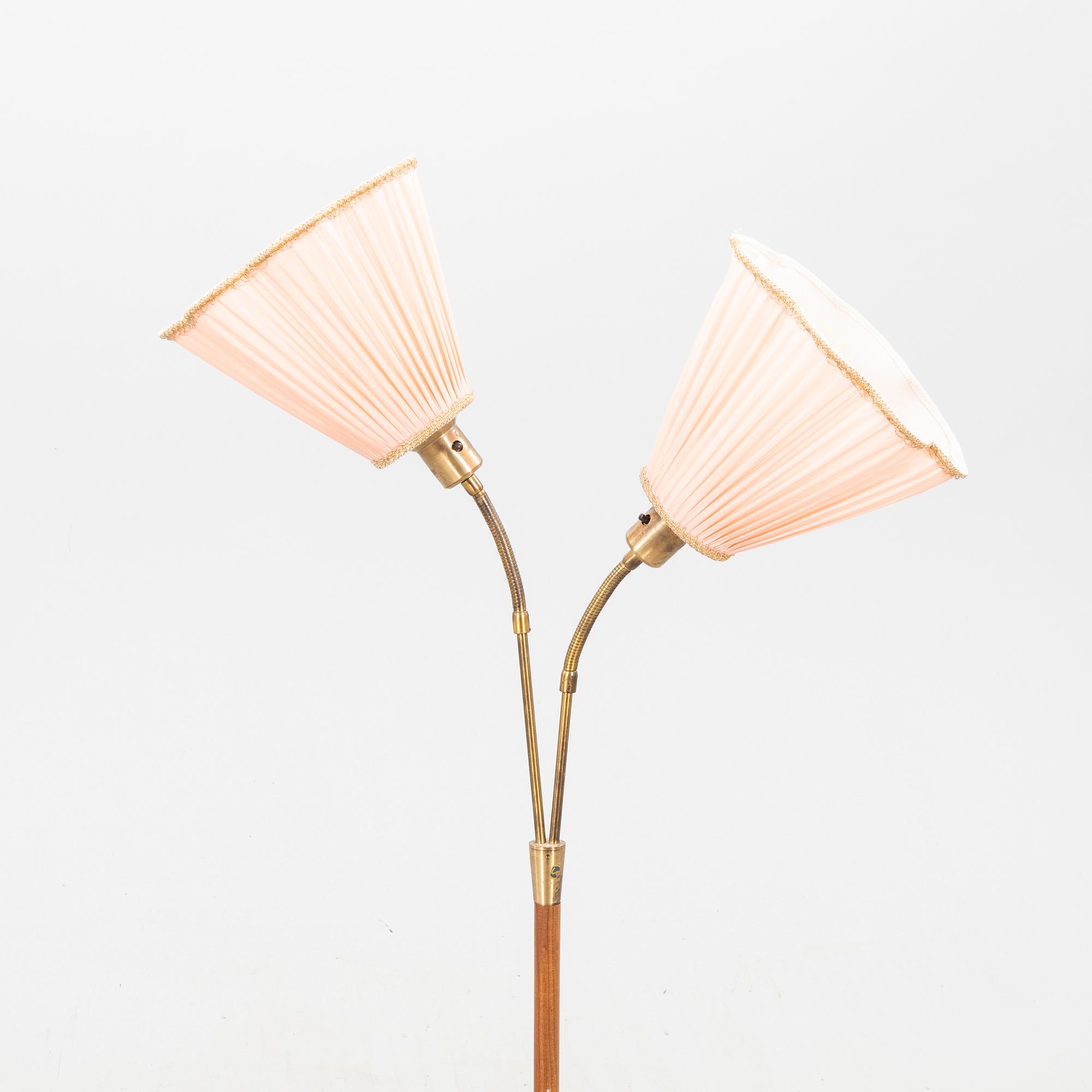 A teak and brass floor lamp from the first half of the 20th century.