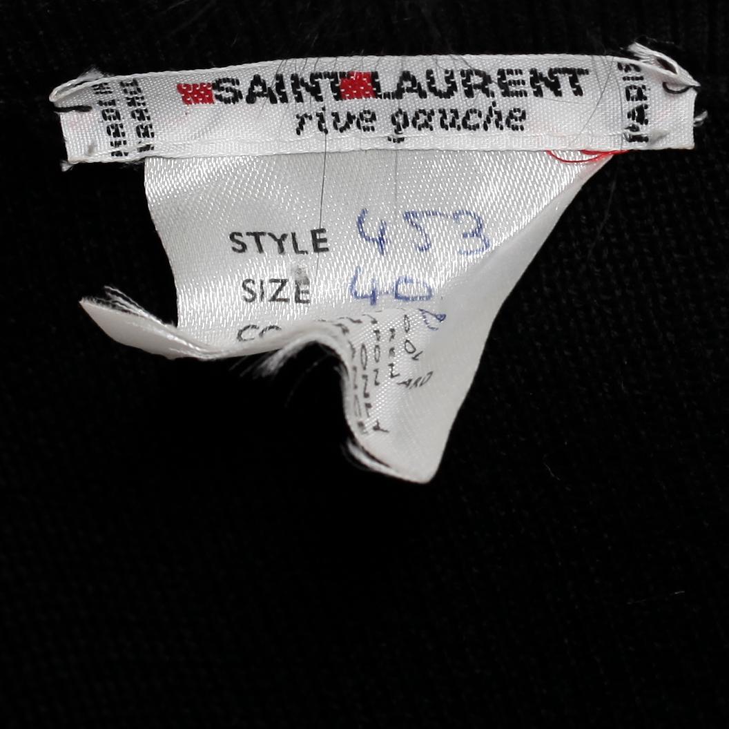 YVES SAINT LAURENT, a black wool sweater with fox pompons.