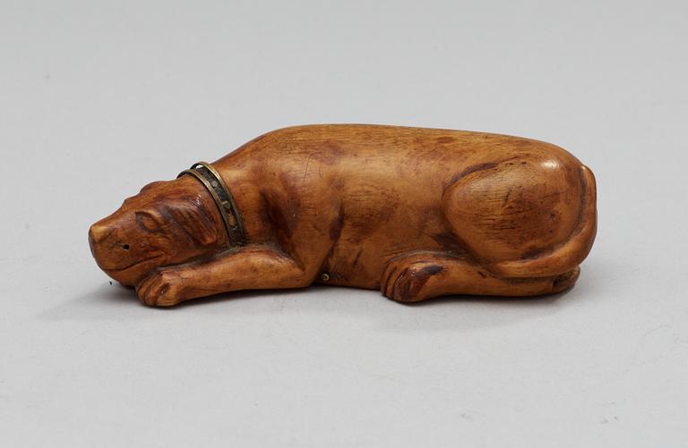 A 19th-20th century birch snuffbox in the shape of a lying dog.