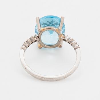 Oval faceted blue topaz and brilliant-cut diamond cocktail ring.