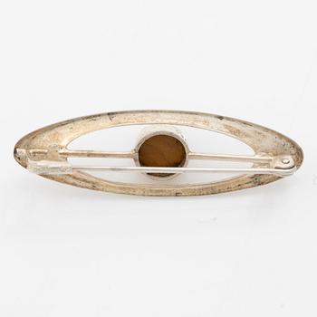 Four silver jewellery pieces: three brooches and a pair of cufflinks. With rose quartz and tiger’s eye. Finnish designers.