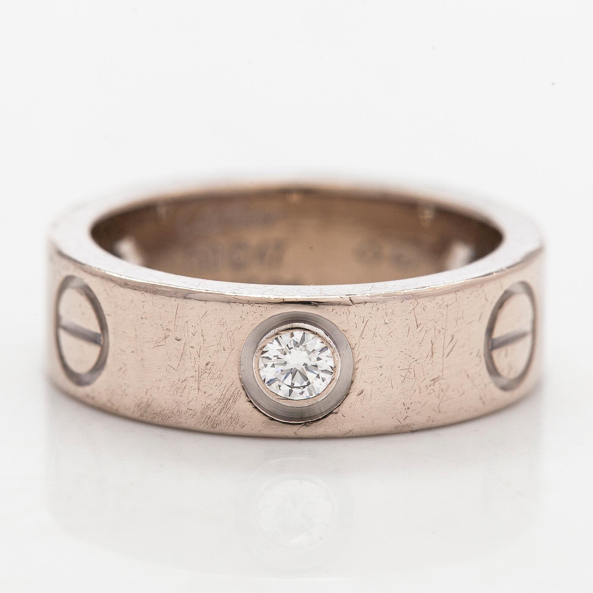 Cartier, an 18K white gold 'Love' ring with three brilliant-cut diamonds.