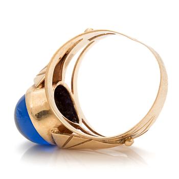 A ring set with an oval, cabochon-cut, synthetic, blue spinel.