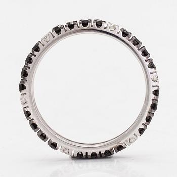 An 18K white gold eternity ring,  with black and white diamonds totalling approximately 0.85 ct, by Lanza Carlo, Italy.
