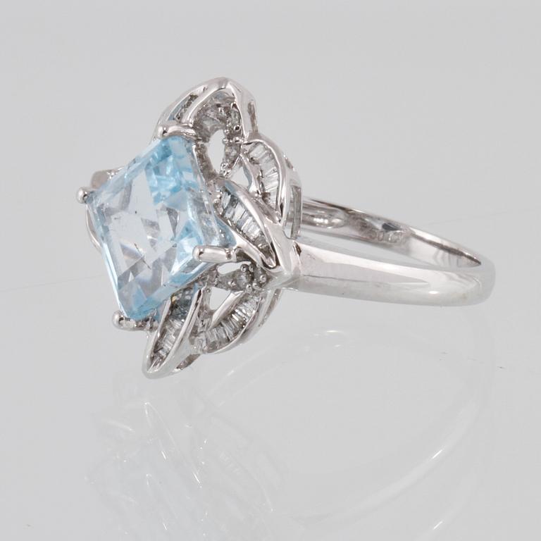 RING, 18K vitguld med carréslipad blå topas 4.07 ct samt baguett och briljantslipade diamanter 0.36 ct. Vikt 4,1 gram.