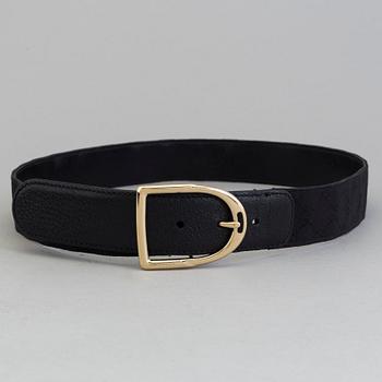 A blach monogram belt by Gucci.