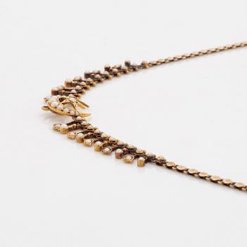 A gold necklace set with pearls.