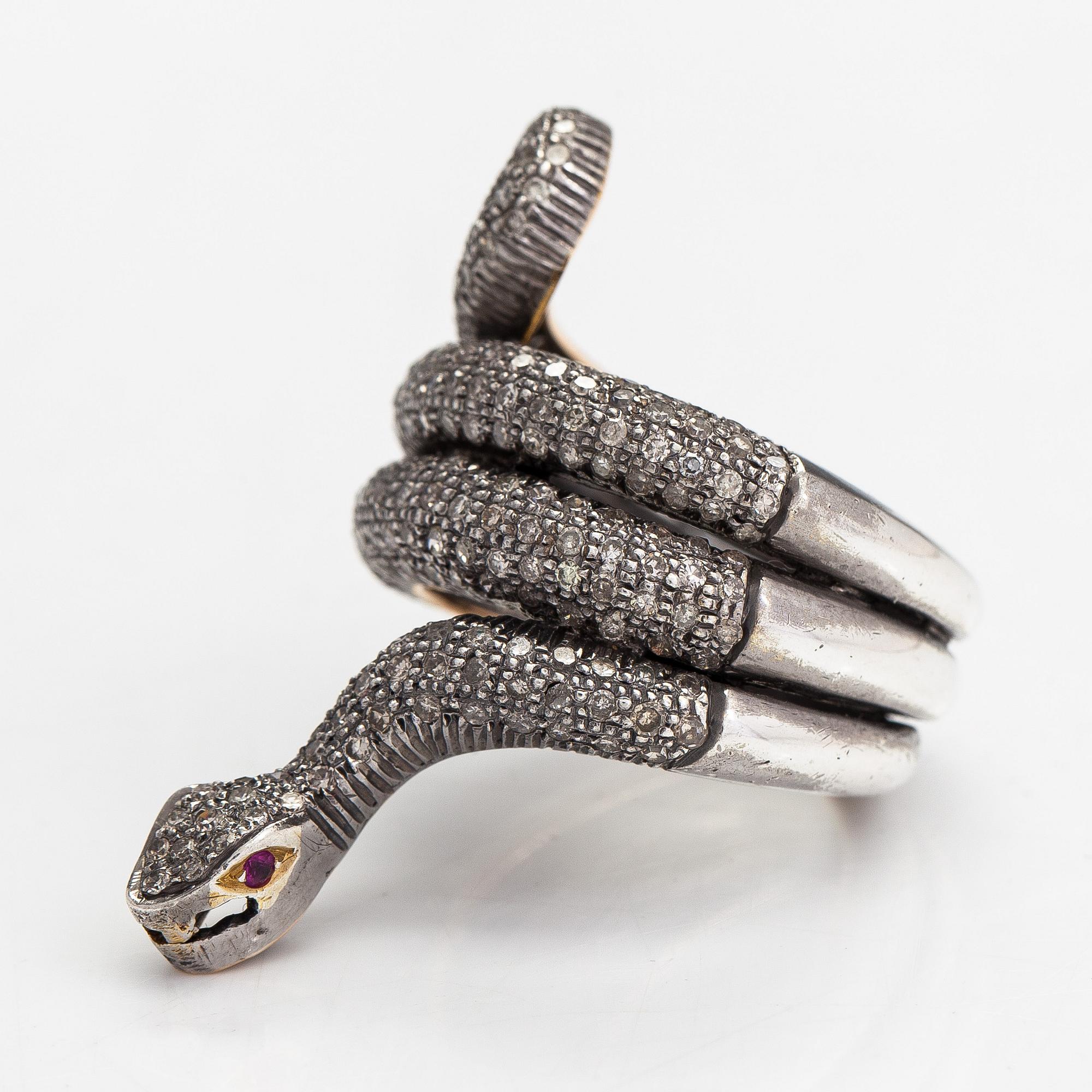 A serpent ring in gold and silver with rubies and single cut diamonds ca 0.88 ct in total.