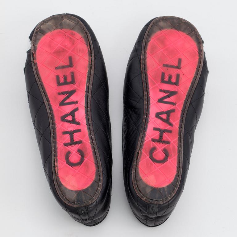 CHANEL, a pair of black leather ballet flats.