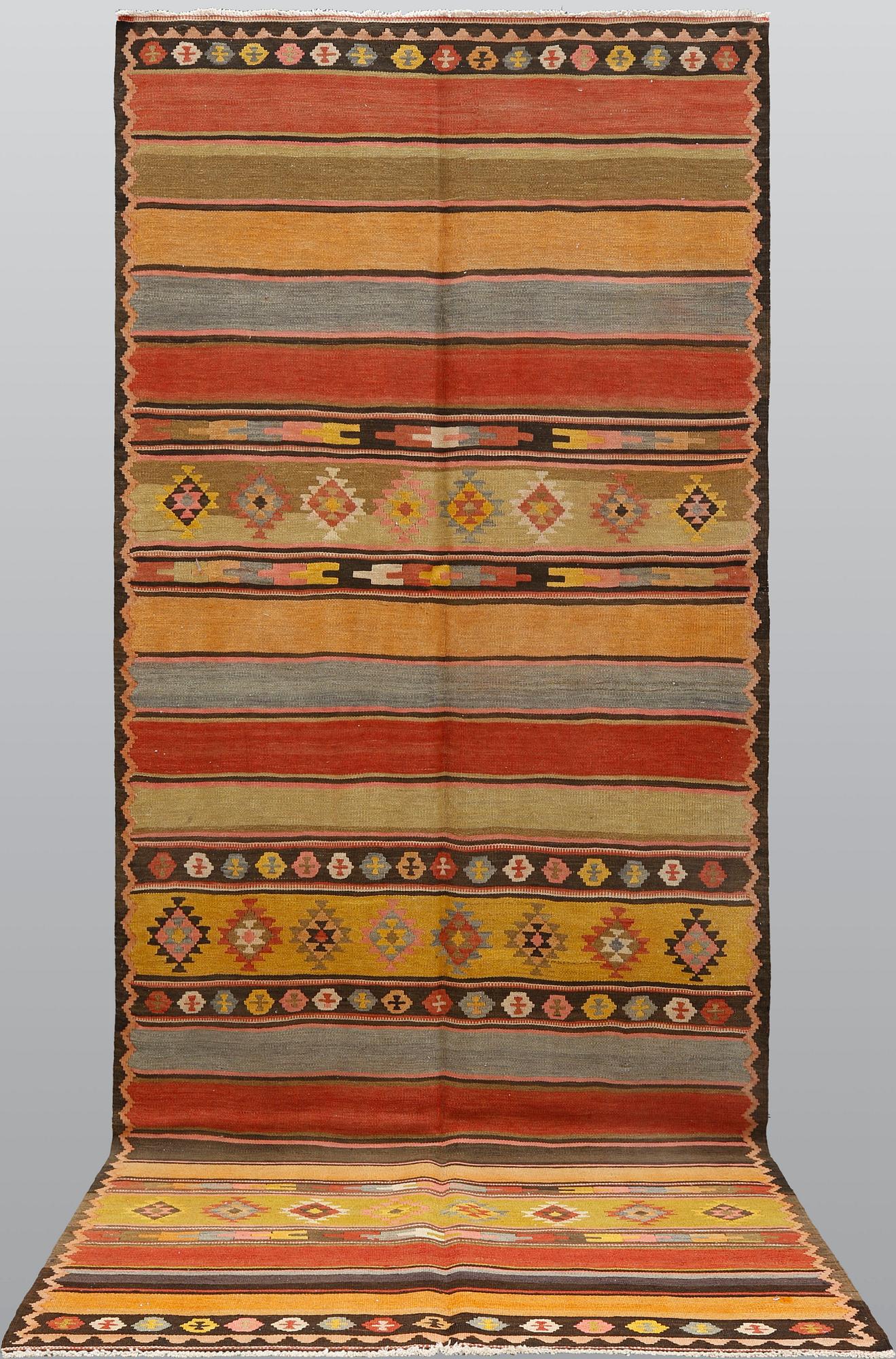 A semi-antique Nomadic Kilim rug, approx. 383 x 153 cm.