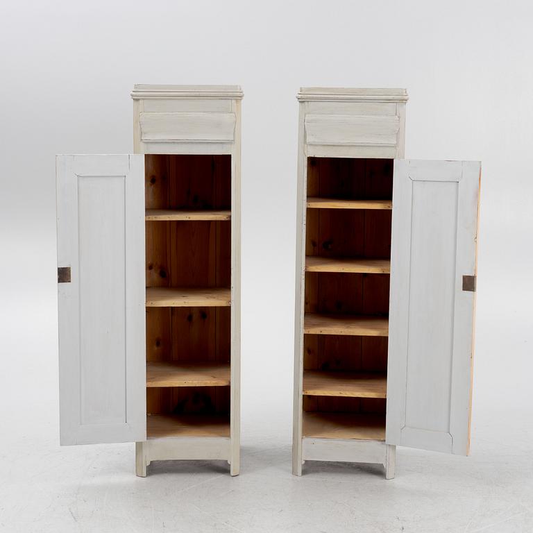 A pair of painted cabinets with a drawer.