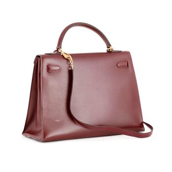 HERMÈS, a burgundy red leather handbag, "Kelly 32".