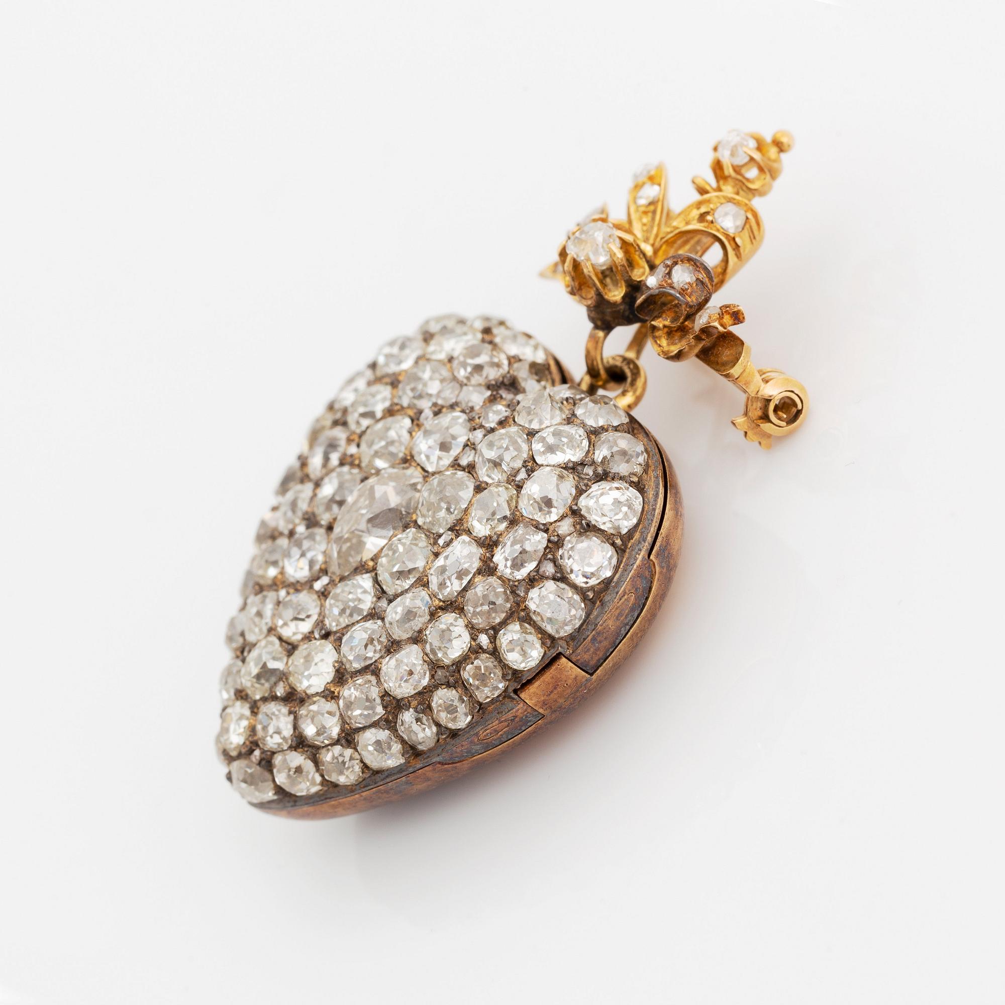 A pendant/locket in 18K gold set with old-cut diamonds, in the form of a heart.