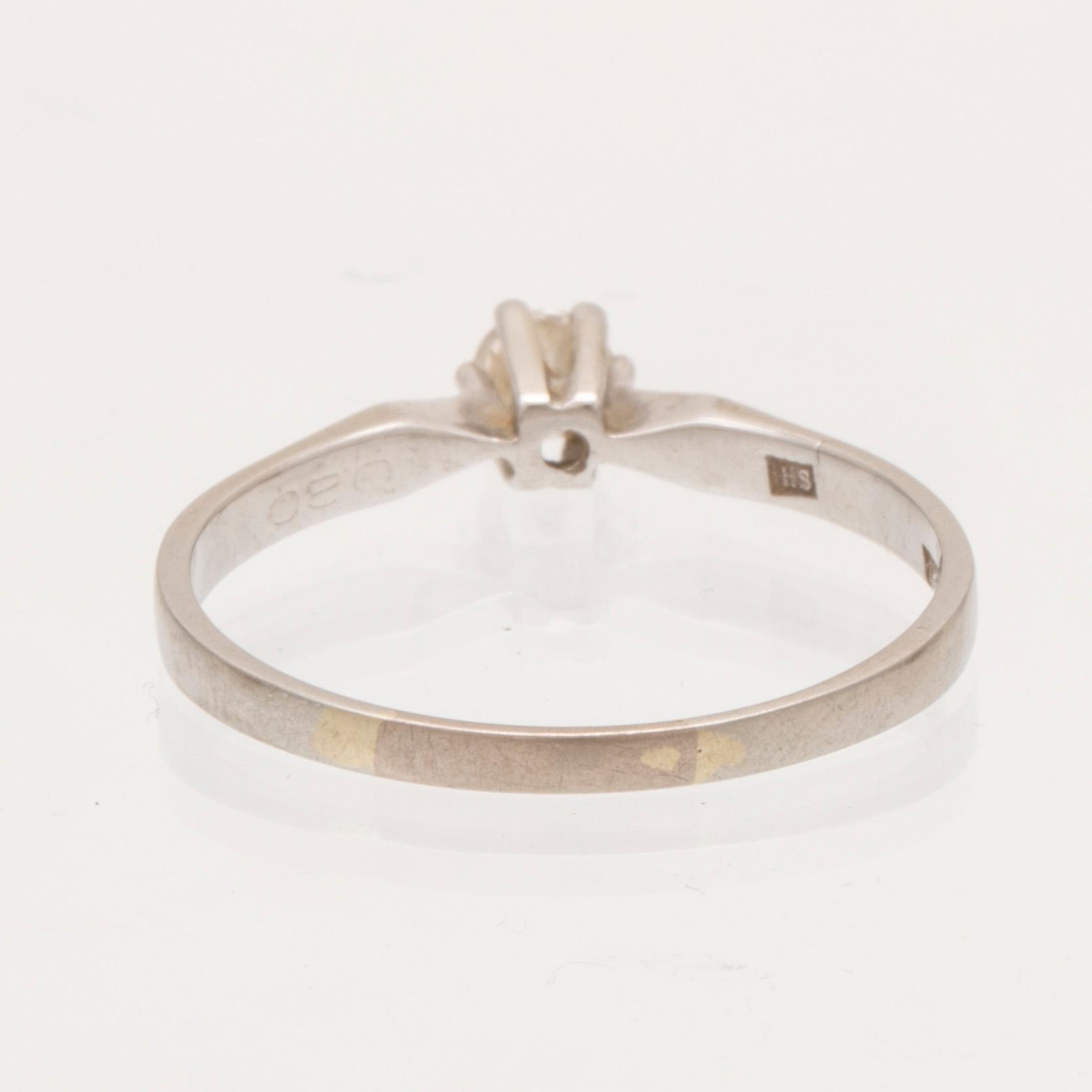 An 18K white gold ring with a round brilliant cut diamond.