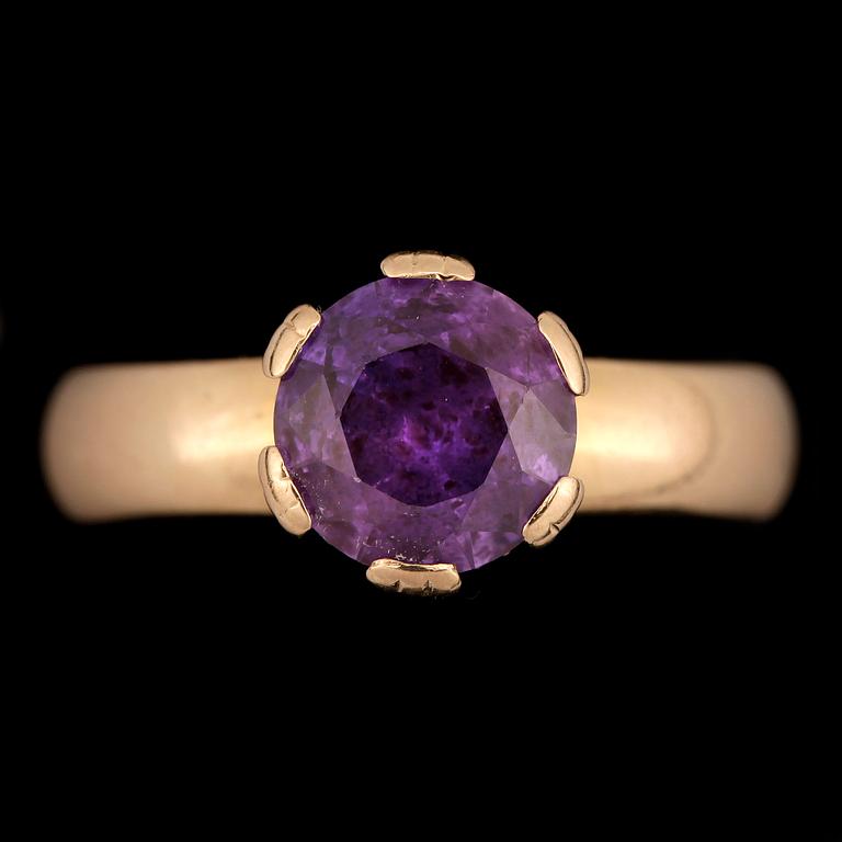 RING, 18k guld med rund fasettslipad violett sten. Vikt 5,7g.