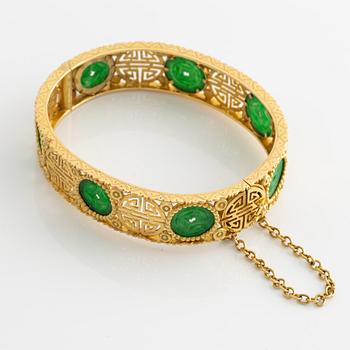 Armring guld med grön sten, troligen jadeit.