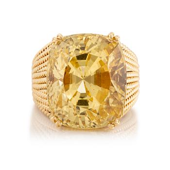 531. A Sterlé 18K gold ring set with a faceted oval yellow sapphire.