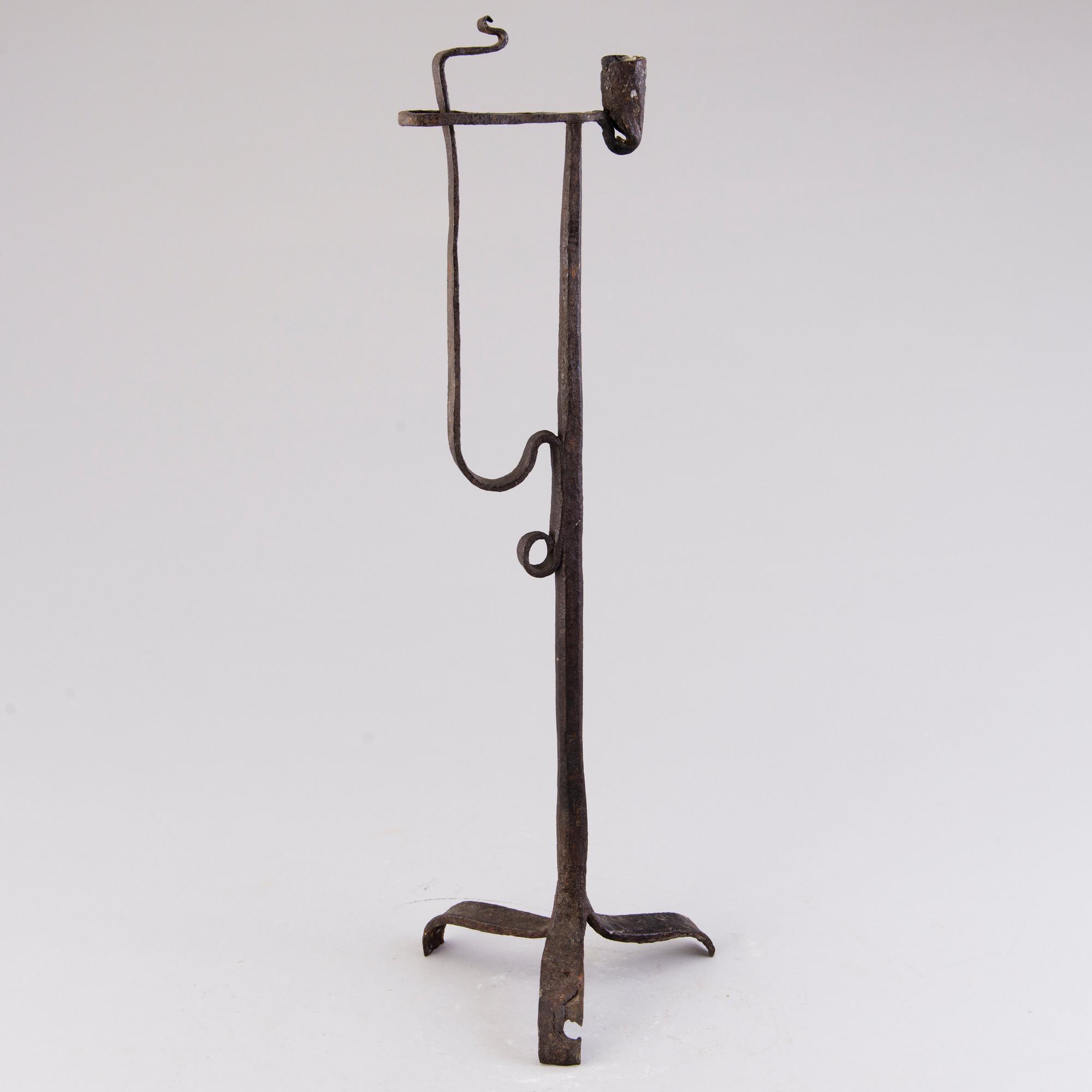 A 18th century wrought iron rush light and candle holder.