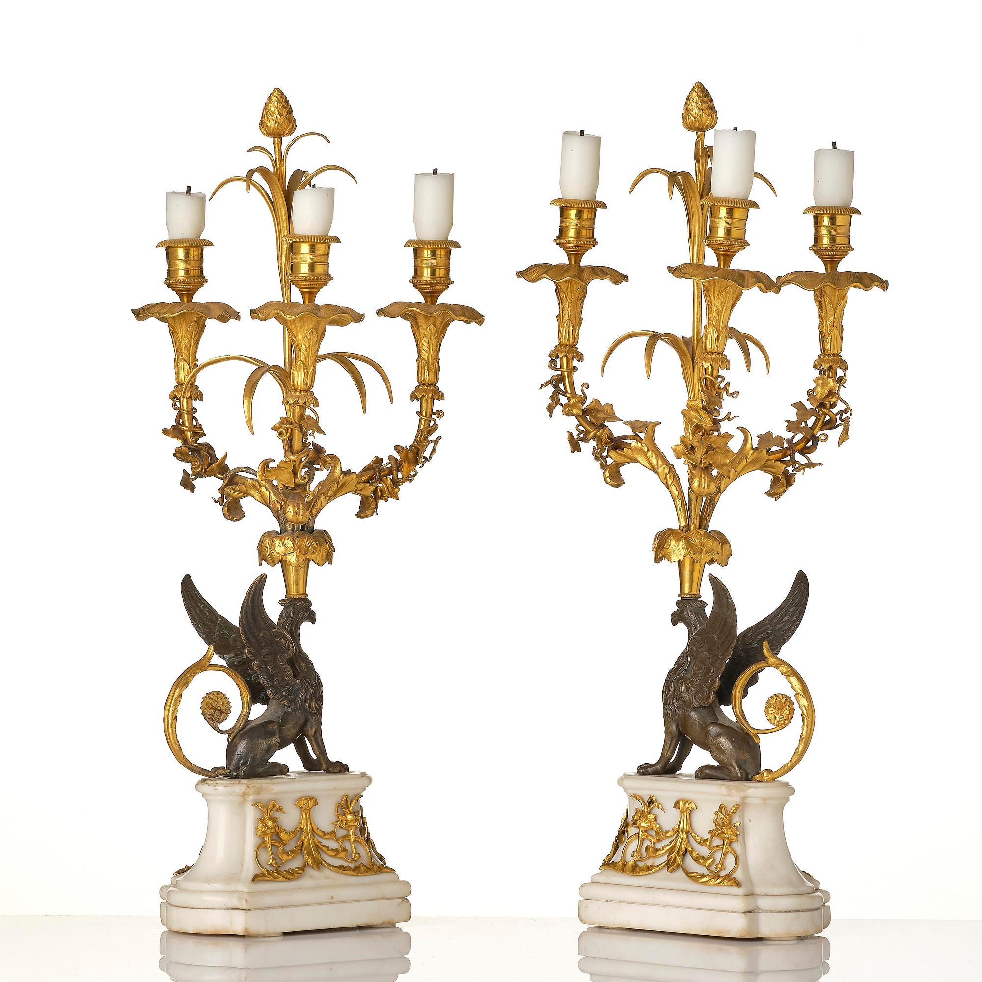 A pair of three-light Louis XVI patinated and ormolu candelabra in the manner of François Rémond, late 18th century.