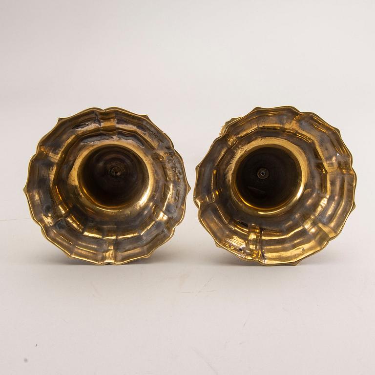 A pair of rococo brass candlesticks, possibly France.