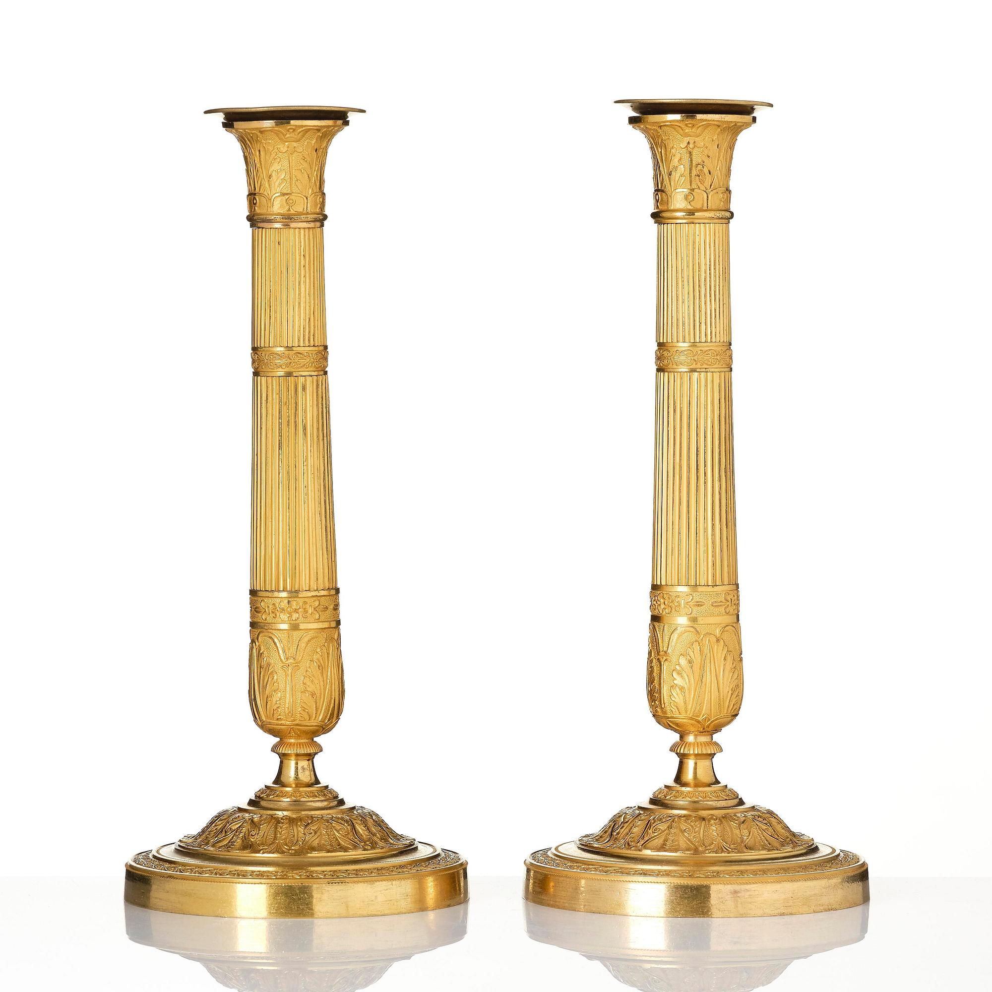 A pair of French Empire ormolu candlesticks, early 19th century.
