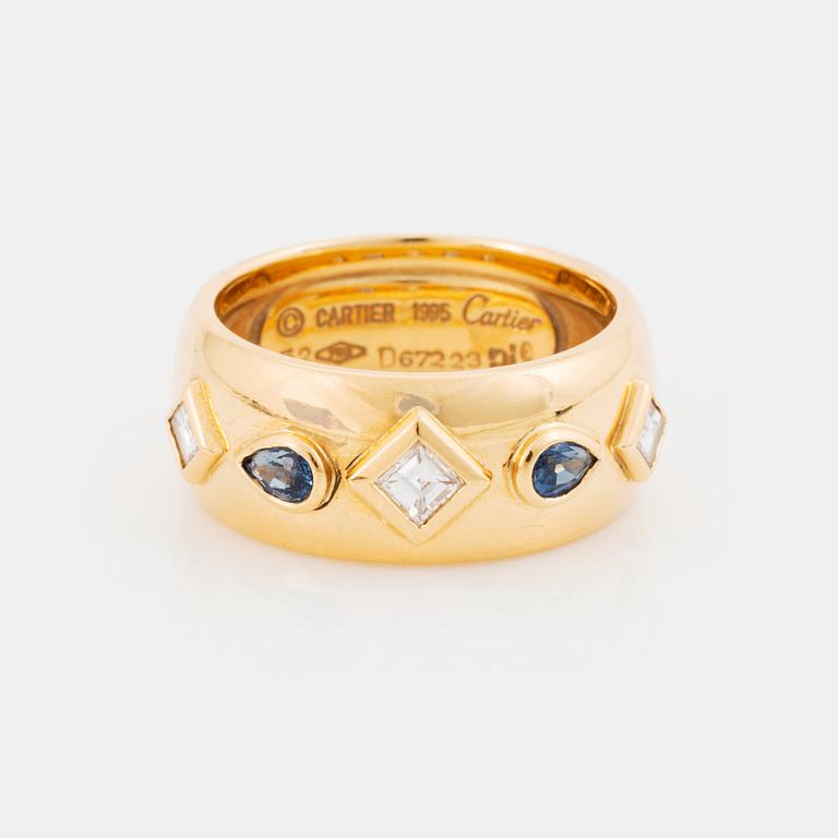 An 18K gold Cartier ring set with step-cut diamonds and faceted sapphires.