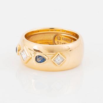 An 18K gold Cartier ring set with step-cut diamonds and faceted sapphires.