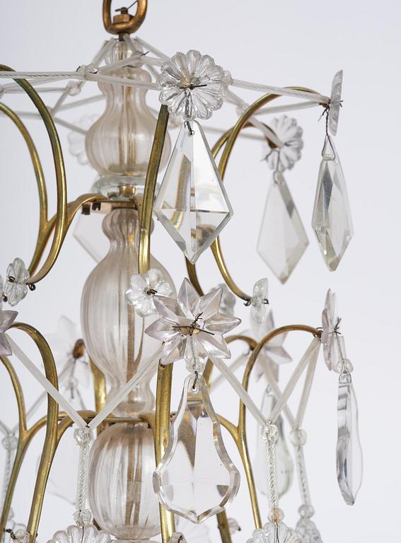 A near pair of rococo-style gilt brass and cut glass six-branch chandeliers, 19th century incorporating older elements.