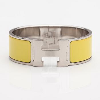 Hermès, A "Click H" bracelet made of metal and yellow enamel. Marked Hermès, ST1105, S, Made in France.