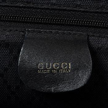 Gucci, A black leather backpack.