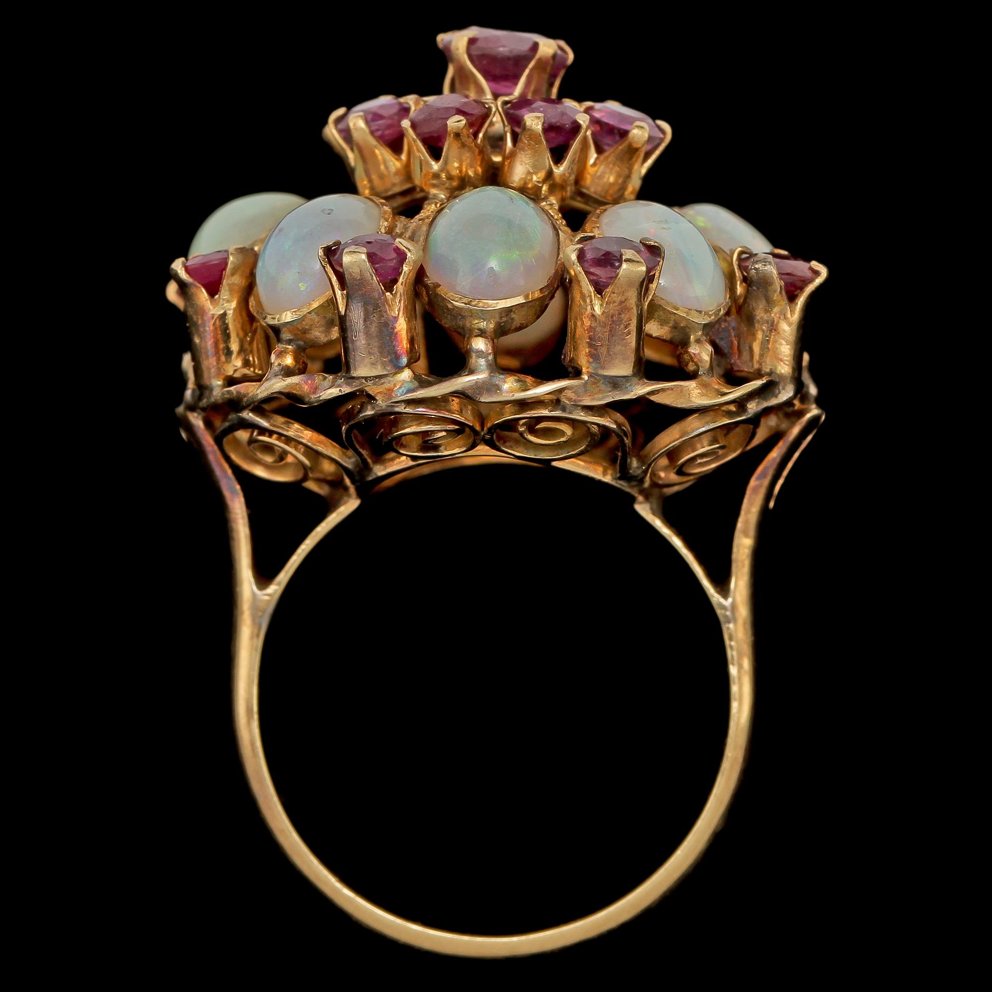 RING, förgyllt silver med 8 cabochonslipade opaler och 17 fasettslipade granater, 1900-tal. Vikt 7 g.