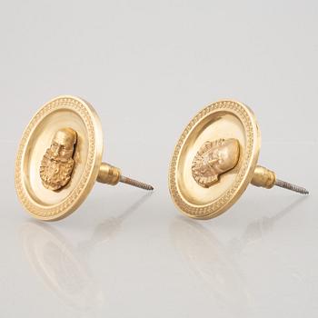 A pair of gilt-bronze Empire-style curtain holders, 19th century.