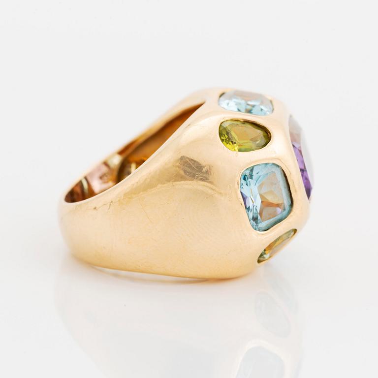 An 18K gold ring set with faceted amethyst, peridot and aquamarine.