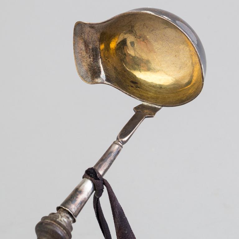 A 19th century silver soup and a sauce ladle with wooden handles.