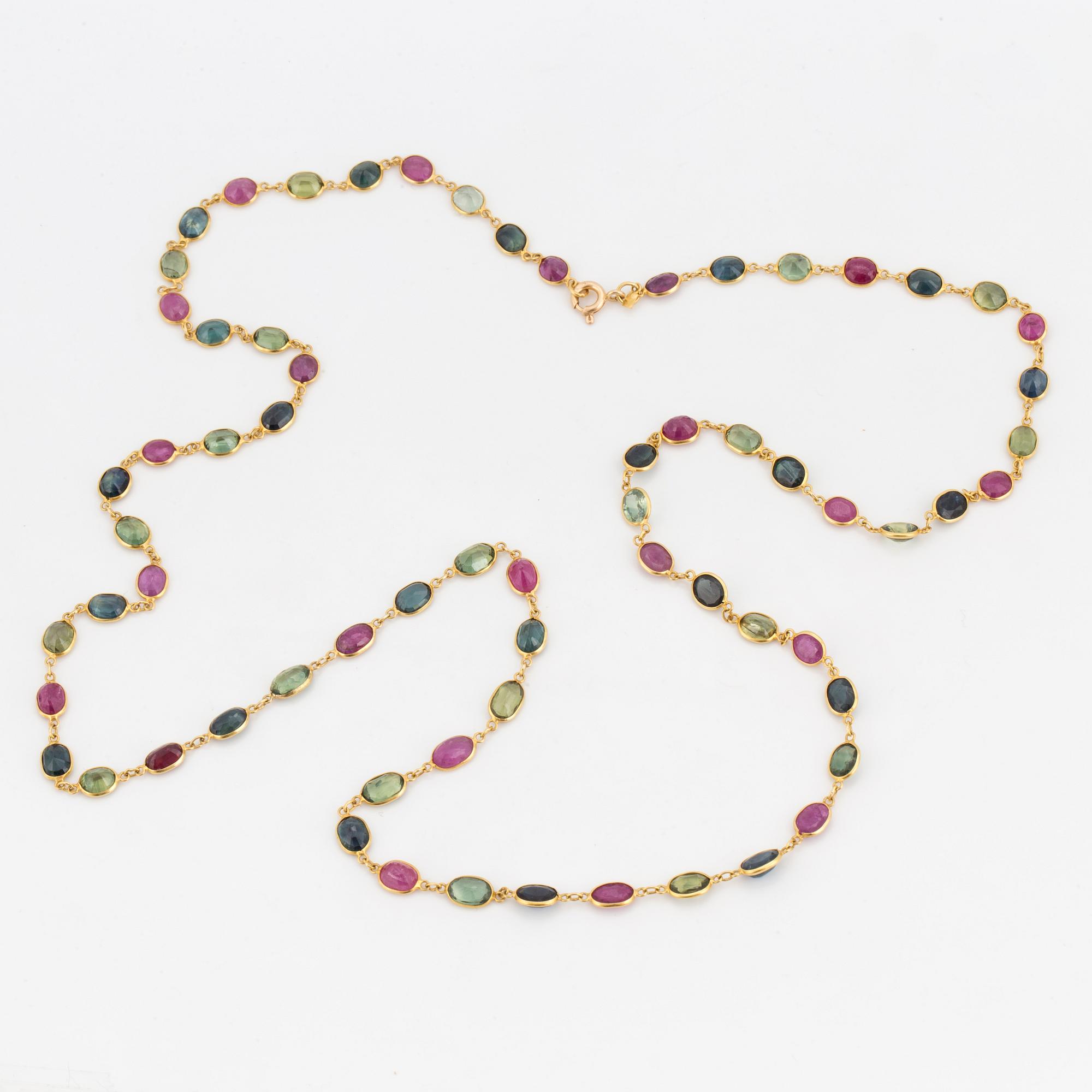 A necklace set with oval, mixed-cut, multi-coloured gemstones.