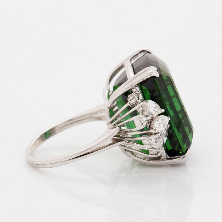 An 18K white gold ring set with a green tourmaline and round- and marquise brilliant-cut diamonds.