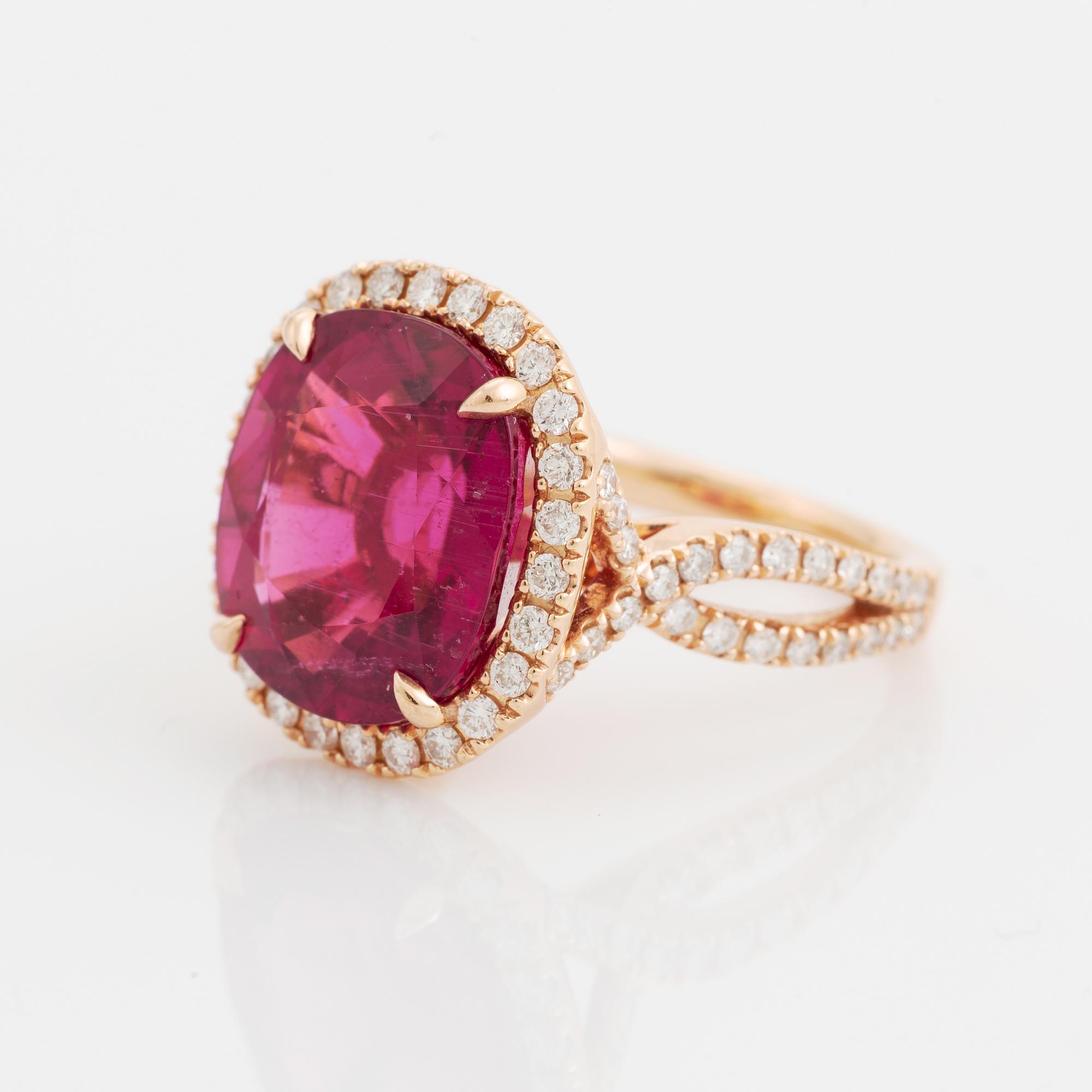An 18K gold ring set with a faceted pink tourmaline and round brilliant-cut diamonds.