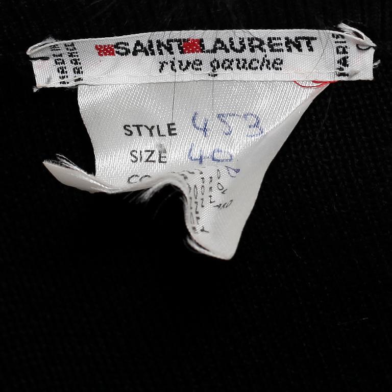 YVES SAINT LAURENT, a black wool sweater with fox pompons.
