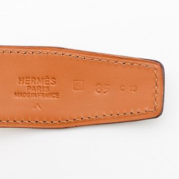 HERMÈS, a green crocodile belt with silver colored H belt buckle.