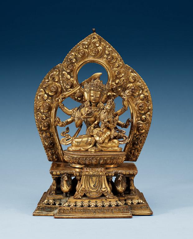 A large gilt bronze Nepal/Sino-Tibetan figure of Buddha, Qing dynasty, presumably Qianlong (1736-95). With an inscription around the base.