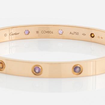 A Cartier "Love" bracelet in 18K rose gold set with colored stones.