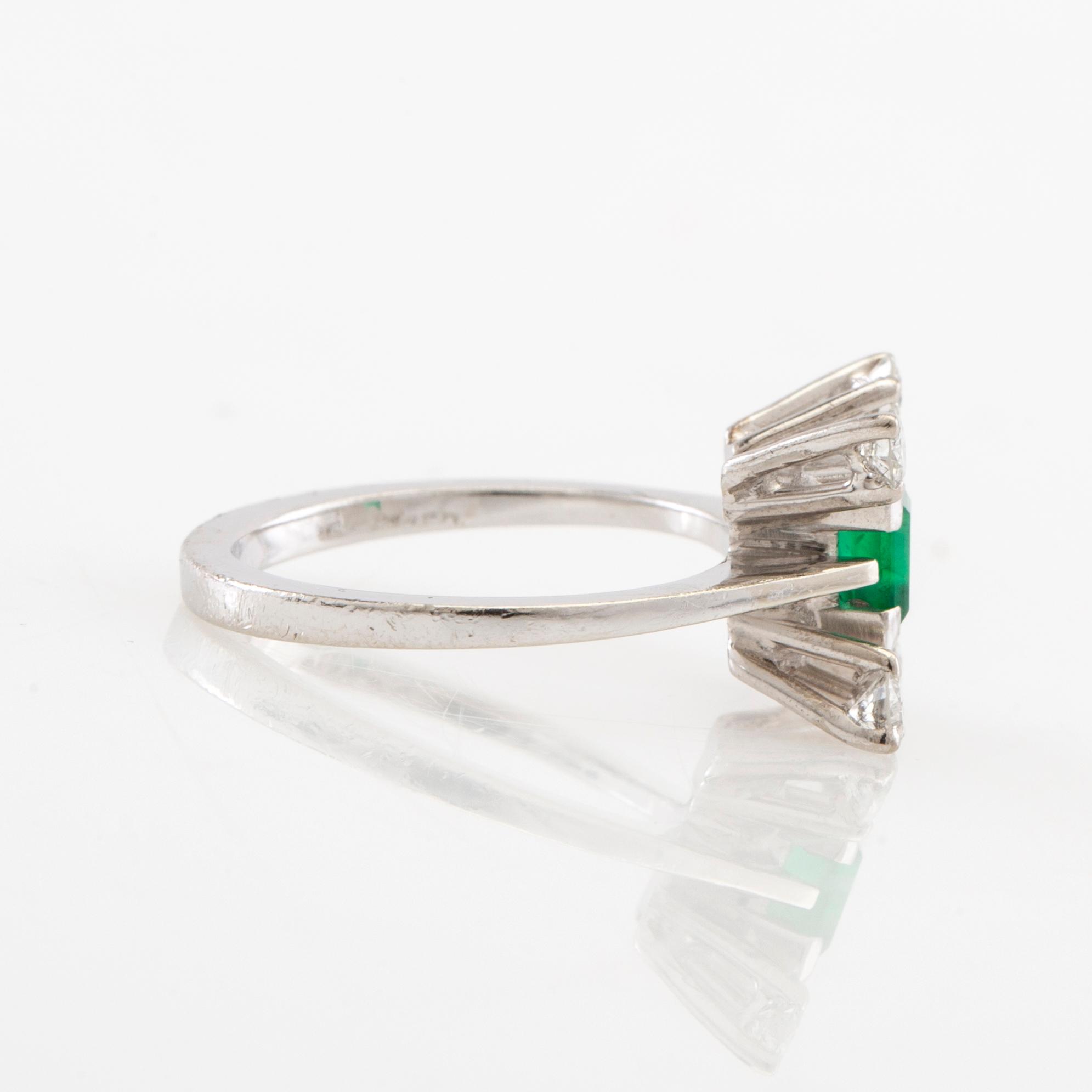 Ring in 18K white gold with a step-cut emerald and round brilliant-cut diamonds.