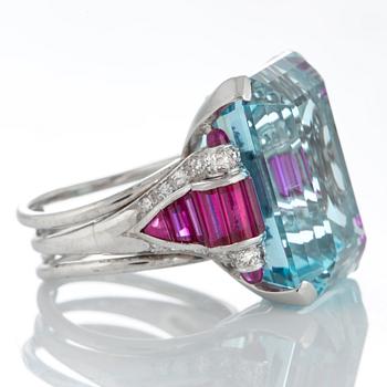 A ring set with a step-cut aquamarine with a weight of ca 35 cts and step-cut rubies ca 1.50 cts.