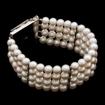 A bracelet with cultured akoya pearls and 18K gold clasp with blue faceted synthetic spinell.