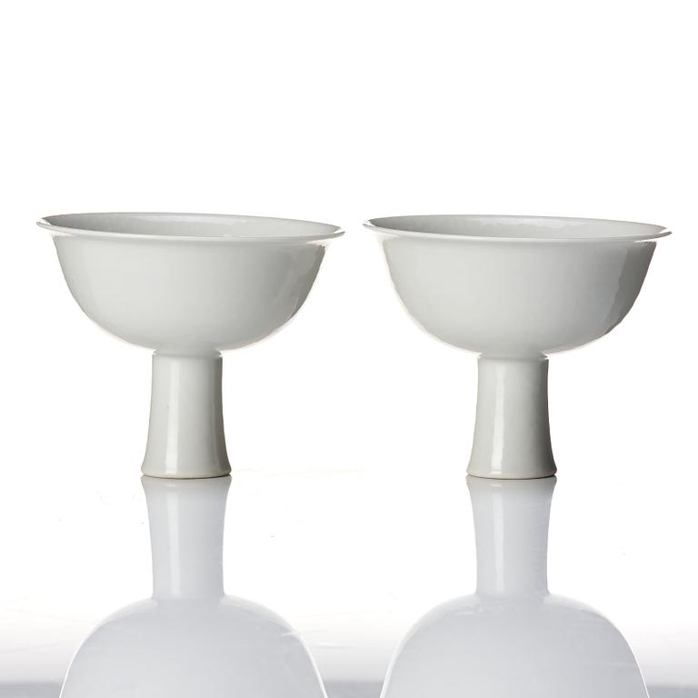 A pair of white glazed anhua stemcups, Qing dynasty, 19th Century.