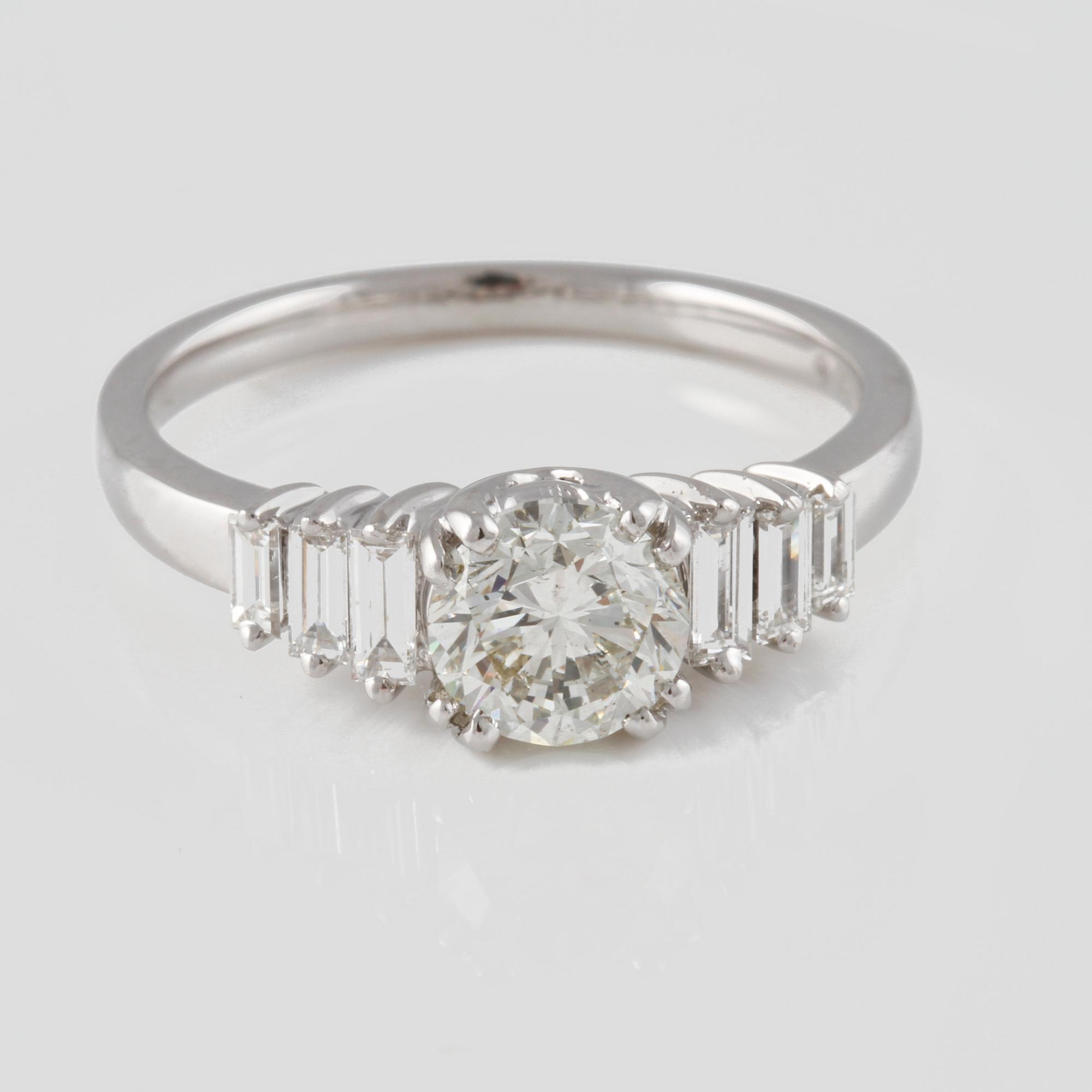 RING, 18K vitguld med briljantslipad diamant ca 1.01 ct samt baguetteslipade diamanter ca 0.29 ct. Vikt 4,0 gram.
