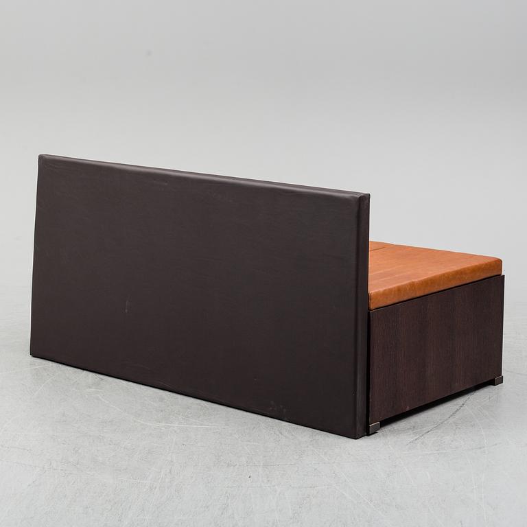 A contemporary bench with drawers and leather upholstery.