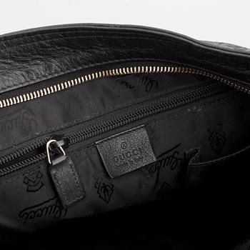Gucci, a leather messenger bag.