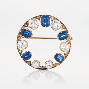 1012. A brooch in 14K gold set with old- and rose-cut diamonds and faceted sapphires.