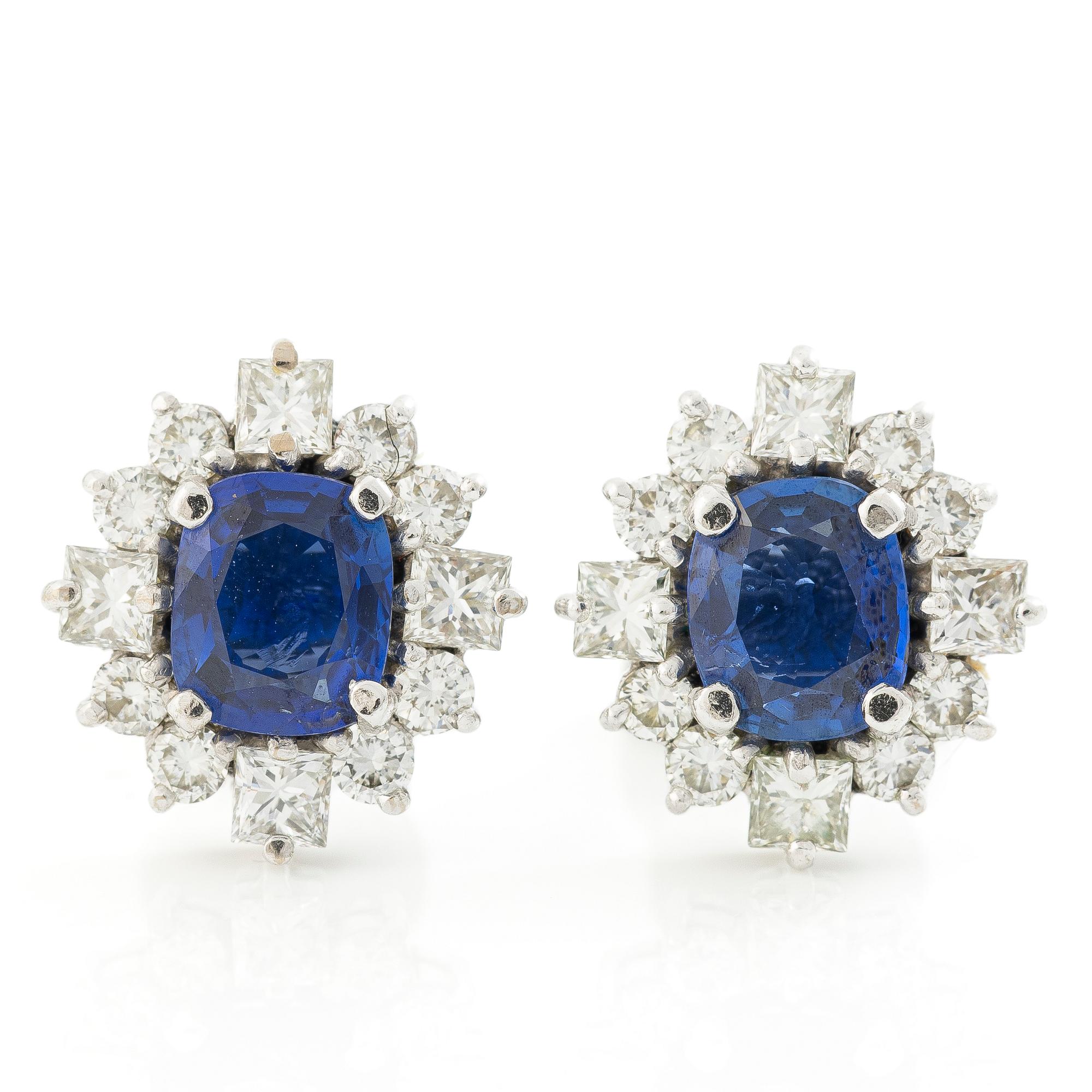A pair of 14K gold earrings with faceted sapphires and round brilliant- and princess-cut diamonds.